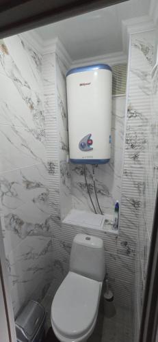 a white bathroom with a toilet and a water tank at Apartament in Bălţi