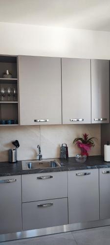 a kitchen with white cabinets and a sink at Tominettihome in Verbania