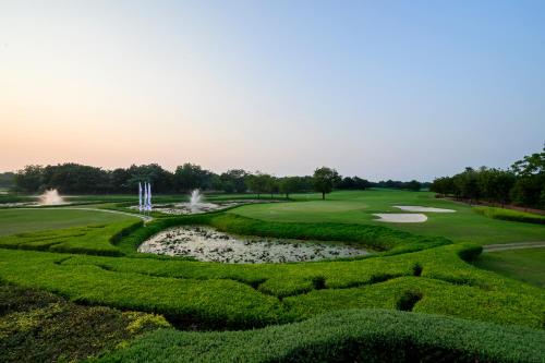 an aerial view of a golf course with a pond at Club Mahindra Kensville in Ahmedabad