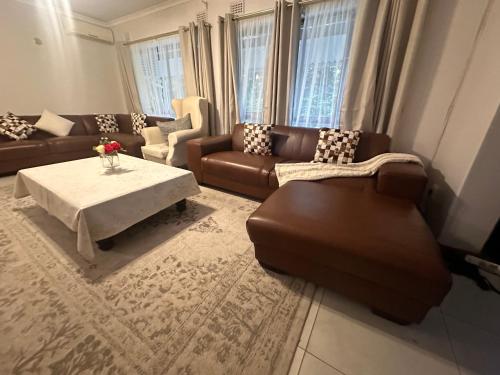 a living room with couches and a coffee table at The Aurum guesthouse in Durban
