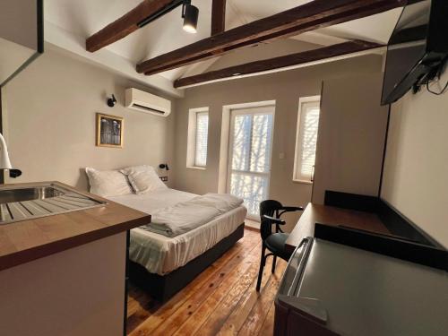 a small bedroom with a bed and a kitchen at Just Home in Varna City