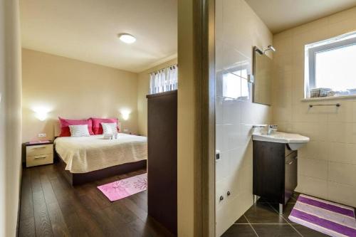 a bedroom with a bed and a bathroom with a sink at Countyside Retreat Six Bedroom Villa with Pool in Gruda