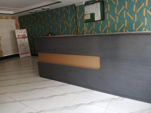 a bar in a waiting room with a sign on the wall at New Era Guest House And Hotel in Multan