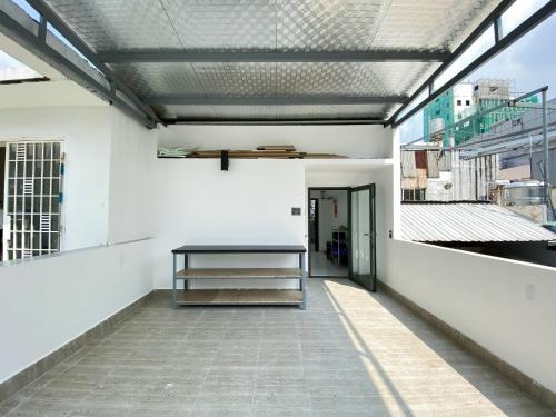a hallway of a white building with a bench at Chip Homestay & Studio in Ho Chi Minh City