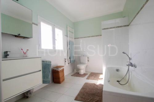 La salle de bains blanche est pourvue d'une baignoire et de toilettes. dans l'établissement Mouans Sartoux, bastide avec magnifique parc et piscine, à Mouans-Sartoux