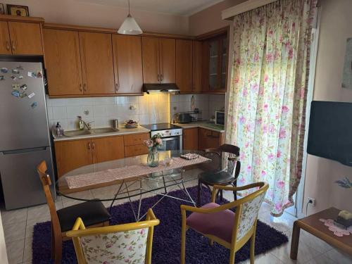 a kitchen with wooden cabinets and a table with chairs at Cozy Naoussa in Naousa Imathias