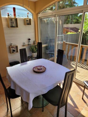 une salle à manger avec une table et des chaises blanches dans l'établissement Un coin de paradis, à La Londe-les-Maures