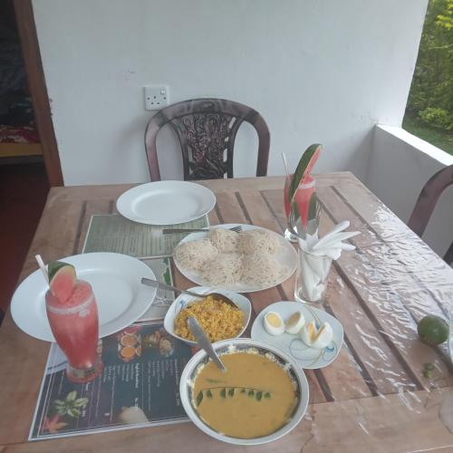 un tavolo in legno con ciotole di cibo sopra di Ella Willow Cottage a Ella