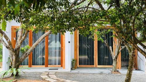 an orange and white building with trees in front of it at Mount Side Hiriketiya in Hiriketiya