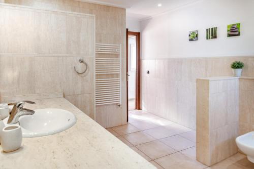 a white bathroom with a sink and a toilet at Es Puig De Portocolom in Cala Murada