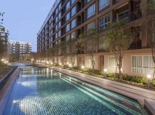 a swimming pool in front of a building at night at Stylish condo in Phuket Kathu centre in Kathu