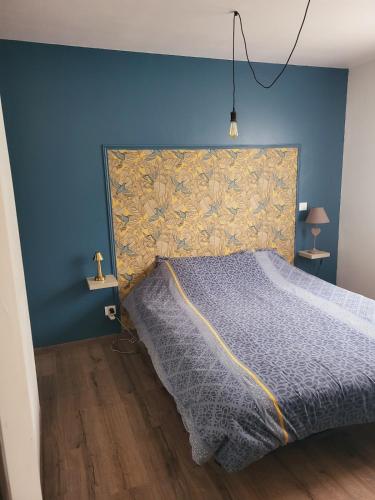 une chambre avec un lit avec un mur bleu dans l'établissement Villa au coeur du village de Castanet, à Castanet