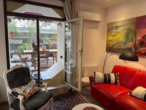 un salon avec un canapé rouge et une porte coulissante en verre dans l'établissement Promenade des Anglais With AC Near Negresco, à Nice