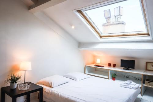 une chambre avec un lit blanc avec une fenêtre dans l'établissement Cannes center apartment, à Cannes