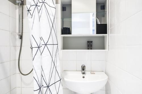 une salle de bain blanche avec un lavabo et une douche dans l'établissement Cannes center apartment, à Cannes