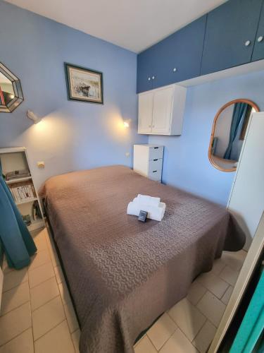 une chambre avec un grand lit et un mur bleu dans l'établissement L'escapade - T2 en centre ville avec terrasse, clim et wifi, au Lavandou