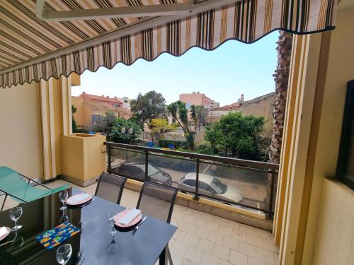 un balcon avec une table et des chaises et une vue dans l'établissement L'escapade - T2 en centre ville avec terrasse, clim et wifi, au Lavandou