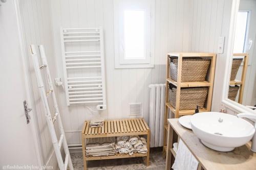 une salle de bain avec un lavabo, des toilettes et un miroir dans l'établissement La Belle Longère, havre de paix 3 étoiles face aux vignes, à Trelou Sur Marne