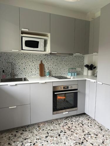 La cuisine est équipée de placards blancs, d'un four micro-ondes et d'un four. dans l'établissement T2 with garden and parking, à Cannes