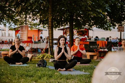 a group of people doing yoga in the grass at ALURE RESIDENCES 11 - 24h self check-in & private parking next to the apartment building included, CITY CENTER right on SNP Square in a quiet passage, new building, best deal in town in Banská Bystrica
