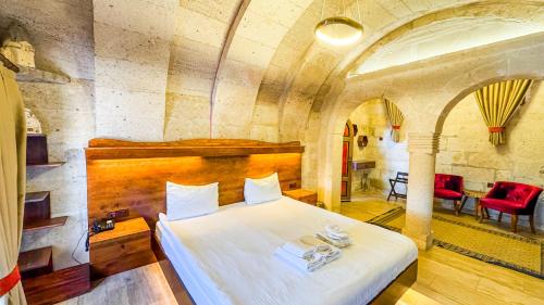 a bedroom with a large white bed in a room at Mimi Cappadocia Luxury Cave Hotel in Uchisar
