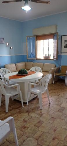 a living room with a couch and a table and chairs at Villa Adele in Agnone Bagni