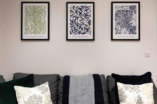 four framed pictures on a wall above a couch at Rock Mill 1 Bed Apartment 27 in Stoney Middleton
