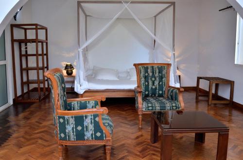 a bedroom with a bed and two chairs and a table at Riviera Garden in Antananarivo