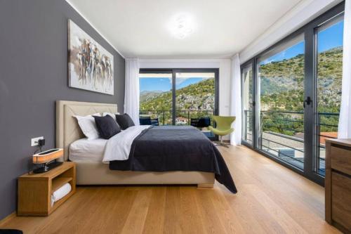 a bedroom with a bed and a large window at Luxury Five Bedroom Villa With Pool and Sunset View in Zaton