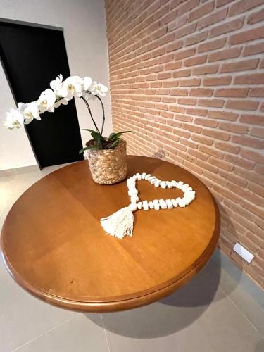 a wooden table with a heart made out of shells at Pousada Cancun Boutique in Guarujá