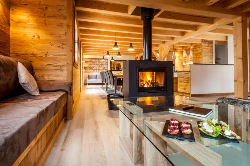 - un salon avec une cheminée dans une maison en rondins dans l'établissement Les Couadzous Samoëns Centre, Sauna, Jacuzzi, 6 chambres, 7 salles de bains, 16 pers 250 m2, à Samoëns