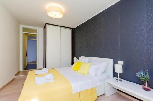a bedroom with a large bed with yellow and white pillows at Elegant Sea-View Villa with Pool in Mlini