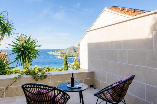 a patio with chairs and a table with a view of the ocean at Elegant Sea-View Villa with Pool in Mlini