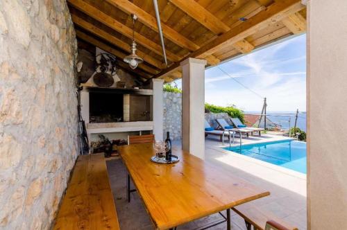 a dining room with a table and a swimming pool at Elegant Sea-View Villa with Pool in Mlini