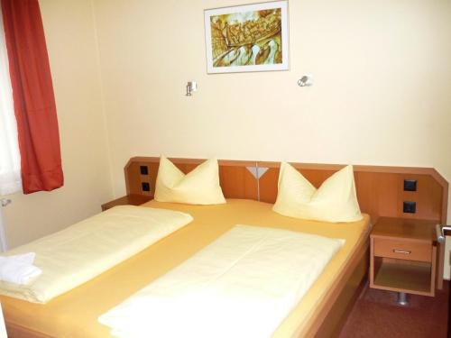 a bedroom with two beds with white pillows at Pension Im Malerwinkel Kallmünz in Kallmünz