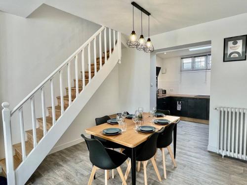 une salle à manger avec une table et des chaises et un escalier dans l'établissement Escapade à Royan - A 5min de la gare jardin, à Royan