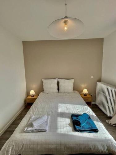 une chambre avec un lit avec deux serviettes bleues dessus dans l'établissement Escapade à Royan - A 5min de la gare jardin, à Royan