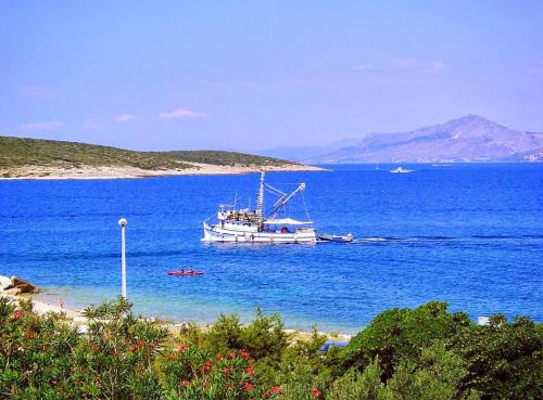 a boat in the water next to a beach at Apartment Ennio in Povlja
