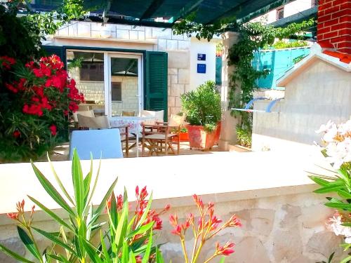a patio with a table and chairs and flowers at Apartment Ennio in Povlja