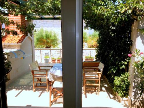 a room with a table and chairs on a patio at Apartment Ennio in Povlja