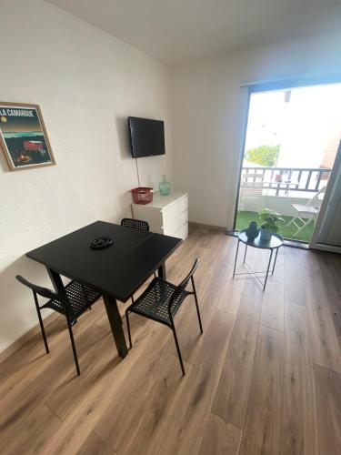 une salle à manger avec une table et des chaises et une grande fenêtre dans l'établissement Studio pour 2 adultes 2 enfants, à Saintes-Maries-de-la-Mer