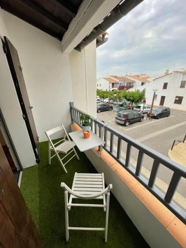d'un balcon avec une table et une chaise offrant une vue sur la rue. dans l'établissement Studio pour 2 adultes 2 enfants, à Saintes-Maries-de-la-Mer