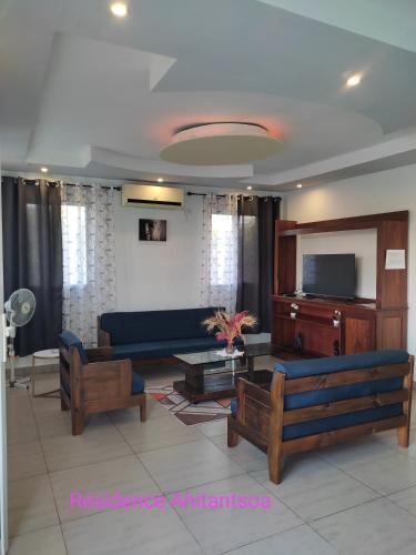 a living room with a blue couch and a tv at Résidence Ahitantsoa Appartement à l'étage in Mahajanga