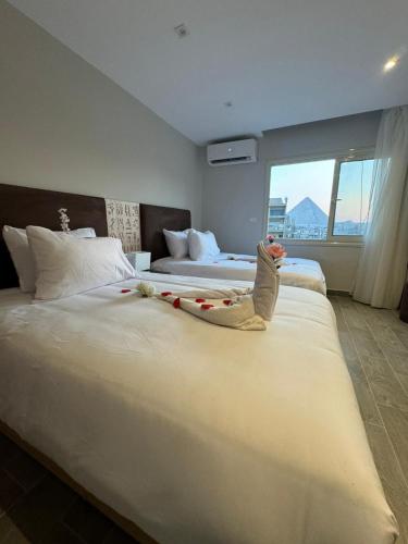 a bedroom with two beds with a child laying on the bed at Khufu Pyramids View Inn in Cairo