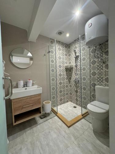 a bathroom with a shower and a toilet and a sink at Khufu Pyramids View Inn in Cairo