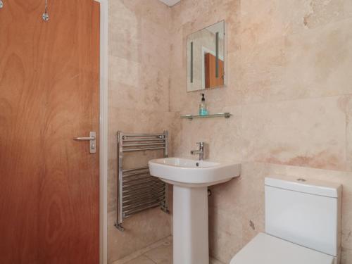 a bathroom with a sink and a toilet and a mirror at Twin Room in Stroud