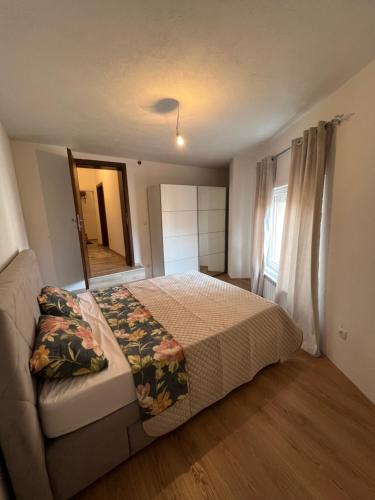 a bedroom with a bed and a couch and a window at Apartmani sara in Plav