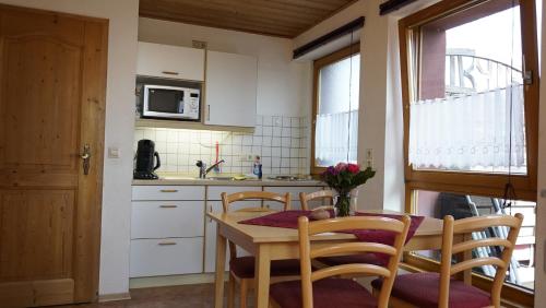 a kitchen with a table and chairs and a microwave at Ferienhof Musch GbR in Rot an der Rot