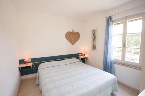 a bedroom with a bed with a heart on the wall at Appartamenti Villa Anna - Goelba in Capoliveri