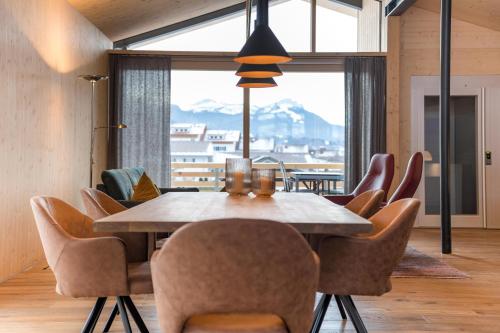 a dining room with a table and chairs and a large window at Alpenhaus Chalet Panoramablick - Bergbahn unlimited inklusive in Oberstdorf